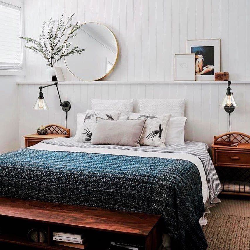 a minimalist bedroom can come in different forms such as a bed without a headboard but a wall shelf to style a mirror and framed artworks.