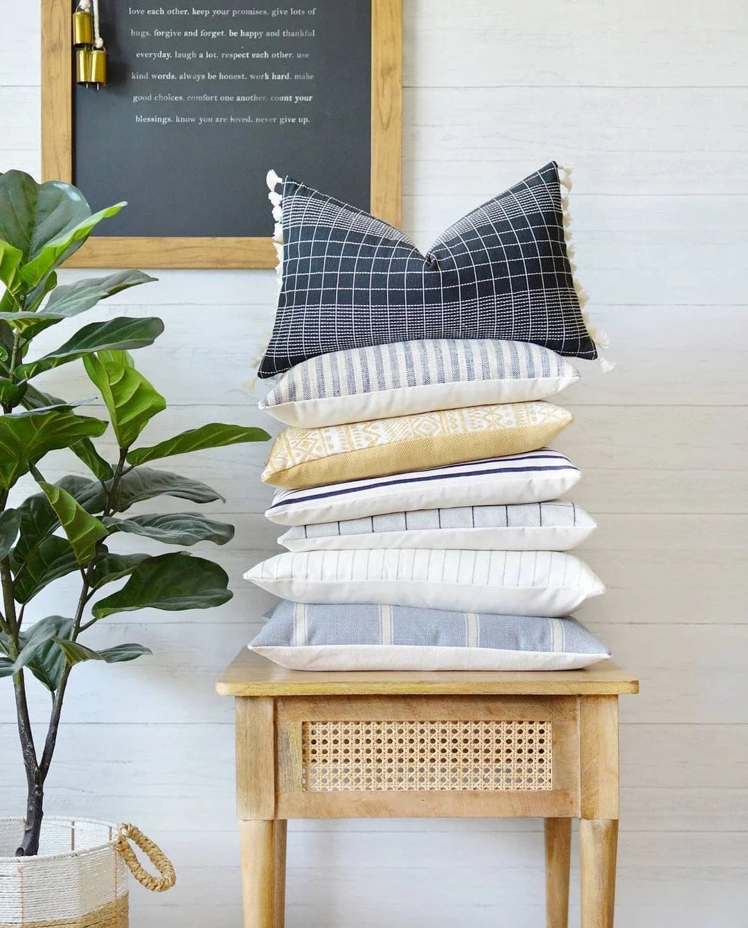 Use bright colored or patterned throw pillows styled on an end table to add visual interest next to a plant and chalkboard for a quick summer decor update.