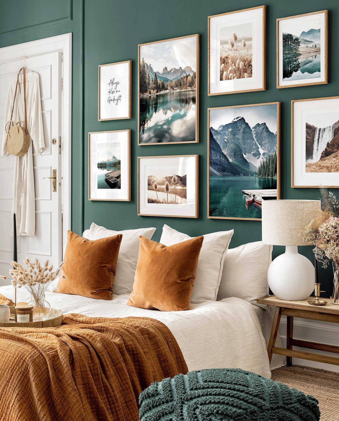 Cozy bedroom with teal accent walls, a bed with white linens and orange pillows, and a gallery wall of nature-themed art.