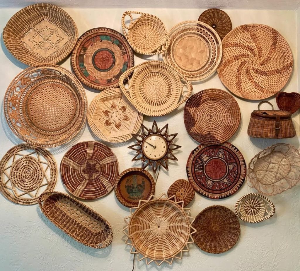 A collection of various bohemian woven baskets and decorative plates displayed on a wall.