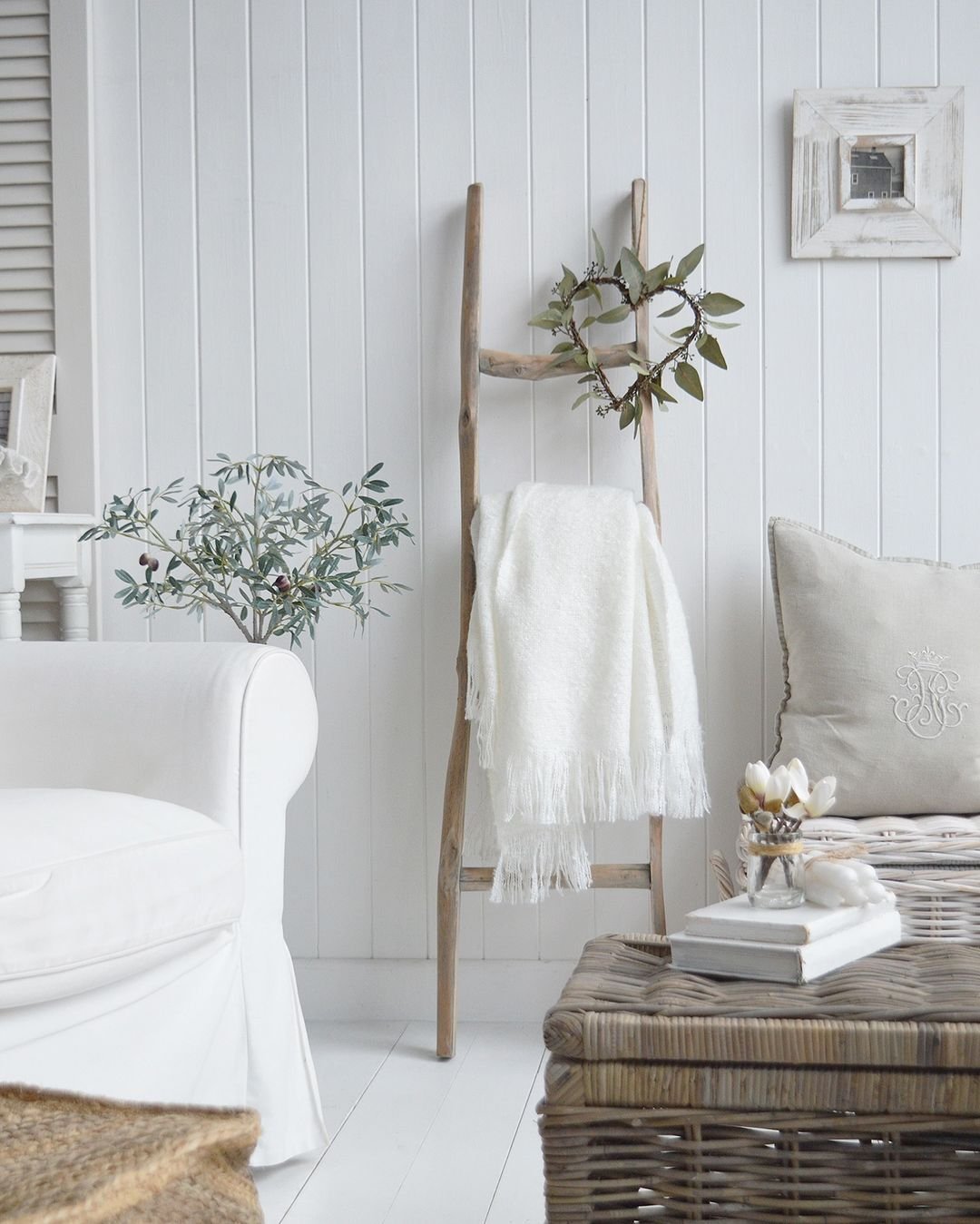 a ladder made of tree branches leaning against a shiplap white wall has everything to up the aesthetic appeal of this living room