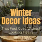 Cozy neutral winter decor with layered textiles, soft greenery, ceramic trees, and warm lighting styled on a tabletop for after Christmas winter decorating.