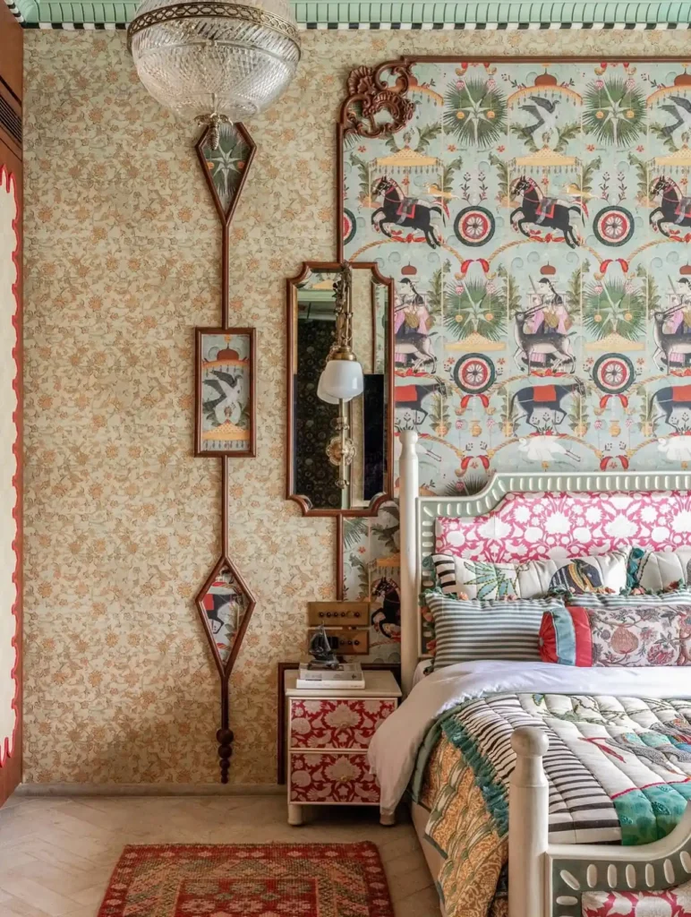 Eclectic bedroom featuring whimsical animal-print wallpaper, ornate wall mirrors, striped pillows, and vibrant mixed-pattern textiles.